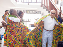 Prof. Glover puts Mr. Walker through his paces on how to wear kente cloth. 